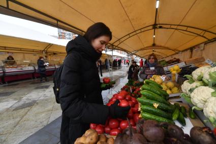 Москва.  Покупательница  на ярмарке выходного дня. Ярмарки выходного дня возобновили свою работу в городе.