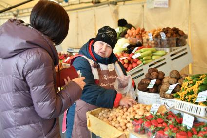 Москва.  Покупательница  на ярмарке выходного дня. Ярмарки выходного дня возобновили свою работу в городе.