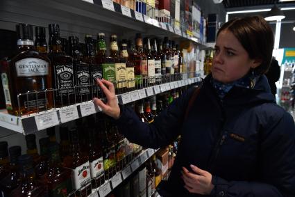 Москва. Девушка в отделе алкогольной продукции в магазине.