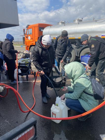 Украина. г.Мариуполь. Местные жители наливают бесплатную воду, привезенную в цистернах.