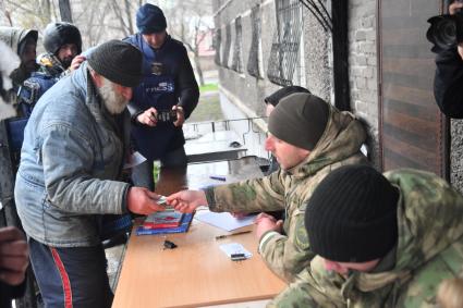 Украина. г.Мариуполь. Местные жители стоят в очереди для проверки паспортов. Проверку паспортов и выдачу пропусков для передвижения по городу осуществляют сотрудники городской милиции.