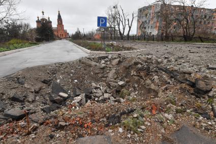 Украина. г.Мариуполь. Левобережный район. На смотровой площадке храм Архистратига Михаила, обстрелянный армией ВСУ. Воронка от бомбы на дороге к храму.