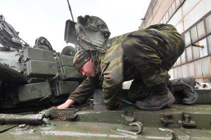 Донецкая область. Ремонт трофейной военной техники. Военнослужащие ремонтируют танк с активной броней.