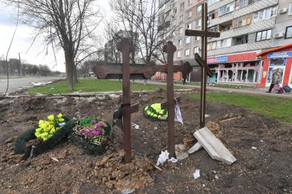 Украина. г.Мариуполь. Местные жители хоронят своих близких в городе. Могилы у дороги.