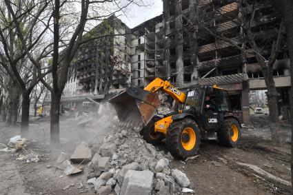 Украина. г.Мариуполь. Работа экскаватора на месте завалов разрушенного жилого дома.