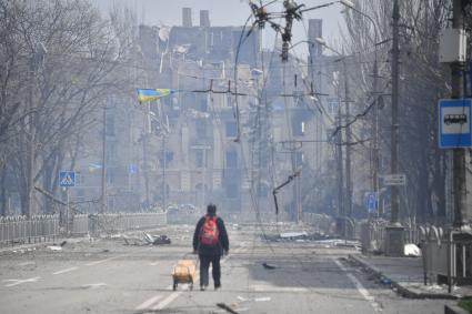 Украина. г.Мариуполь. Мужчина везет на тележке коробку с гуманитарной помощью.