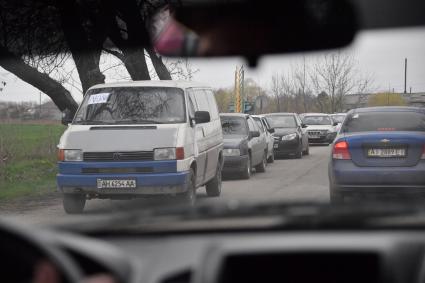 Украина. г.Мариуполь. Надпись `Люди` на микроавтобусе, следующим в потоке машин.