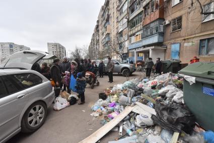 Украина. г.Мариуполь. Местные жители стоят в очереди за гуманитарной помощью, привезенной на машине.