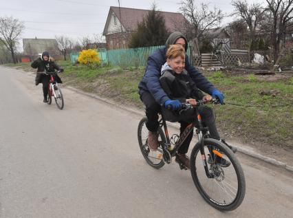 Украина. г.Мариуполь. Подростки едут на велосипедах.