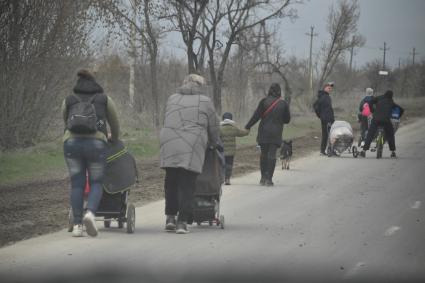 Украина. г.Мариуполь. Местные жители и дети идут с вещами по дороге.