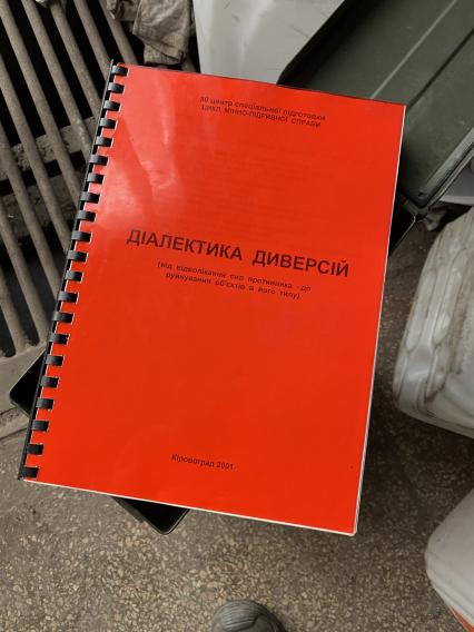 Донецкая область. г.Мариуполь. Завод Ильича, освобожденный от военнослужащих ВСУ. Папка с надписью `Диалектика диверсий`, найденная в ремонтном боксе среди военной документации.