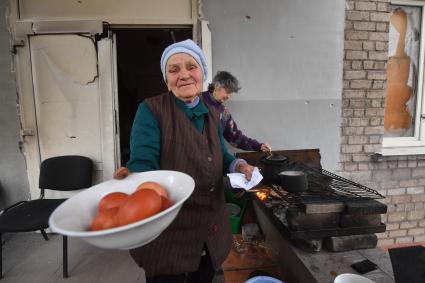 Донецкая область. г. Мариуполь. Бабушка Оля угощает крашенным к Пасхе яйцом.