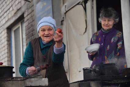 Донецкая область. г. Мариуполь. Бабушка Оля угощает крашенным к Пасхе яйцом.