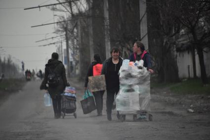 Донецкая область. г.Мариуполь. Жители города с вещами идут по улице.