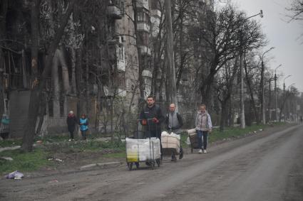 Донецкая область. г.Мариуполь. Жители города с вещами идут по улице.