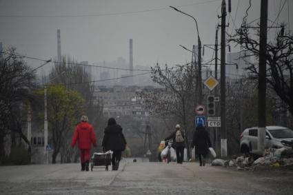 Донецкая область. г.Мариуполь. Жители города с вещами идут по улице.