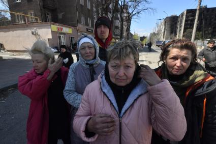 Донецкая область. г.Мариуполь. Люди в разрушенной в результате боев центральной части города.