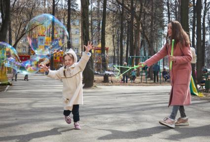 Пермь.  Женщина с девочкой  гуляют в парке.