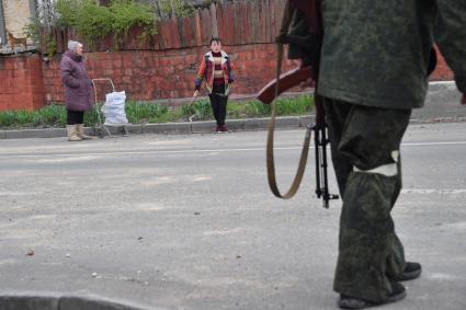 Донецкая область. г.Мариуполь.  Военнослужащий ДНР и местные жители  на одной из улиц  города в окрестностях  завода `Азовсталь`.