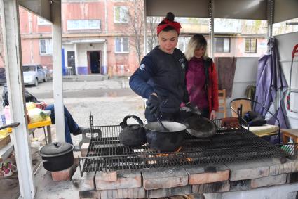 Донецкая область. г.Мариуполь. Женщины готовят еду на улице в одном из дворов города.