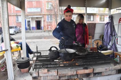 Донецкая область. г.Мариуполь. Женщины готовят еду на улице  в одном из дворов города.