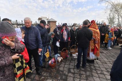 Волноваха, Донецкая народная республика. Верующие и священнослужитель во время освящения пасхальных яиц и куличей после пасхальной службы в Православном храме.