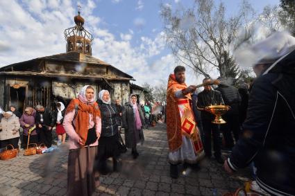 Волноваха, Донецкая народная республика. Верующие и священнослужитель во время освящения пасхальных яиц и куличей после пасхальной службы в Православном храме.