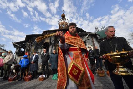 Волноваха, Донецкая народная республика. Верующие и священнослужитель во время освящения пасхальных яиц и куличей после пасхальной службы в Православном храме.