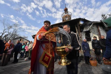 Волноваха, Донецкая народная республика. Верующие и священнослужитель во время освящения пасхальных яиц и куличей после пасхальной службы в Православном храме.