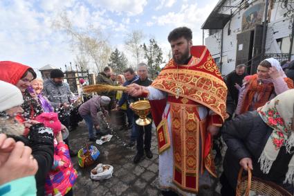 Волноваха, Донецкая народная республика. Верующие и священнослужитель  во время освящения пасхальных яиц и куличей после пасхальной службы в Православном храме.