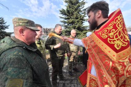 Волноваха, Донецкая народная республика. Верующие и священнослужитель  во время освящения пасхальных яиц и куличей после пасхальной службы в Православном храме.