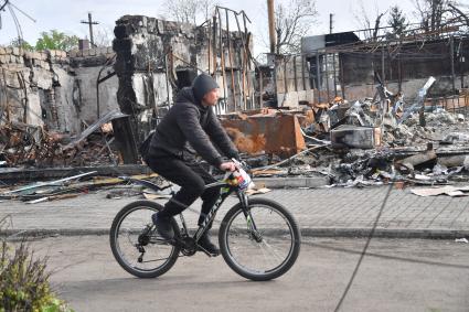 Волноваха, Донецкая народная республика. Мужчина на велосипеде на улице разрушенного, в результате военных действий, города.