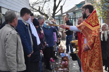 Волноваха, Донецкая народная республика. Верующие и священнослужитель  во время освящения пасхальных яиц и куличей после пасхальной службы в Православном храме.