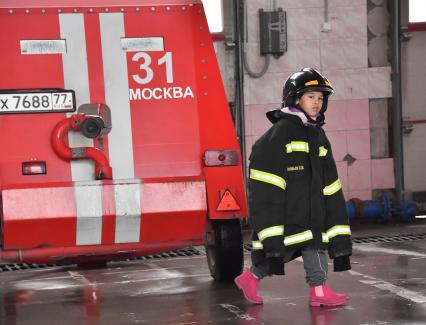 Москва. Мальчик в куртке пожарного во время  посещения Московской пожарной части №31 юными спасателями и их родителями в преддверии Дня гражданской обороны и МЧС России.