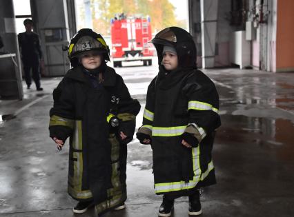 Москва. Мальчик в куртке пожарного во время  посещения Московской пожарной части №31 юными спасателями и их родителями в преддверии Дня гражданской обороны и МЧС России.