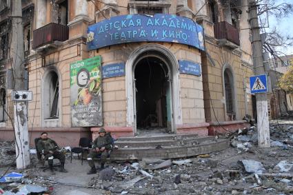 Мариуполь, Донецкая народная республика. Военнослужащие ДНР сидят у разрушенных домов.