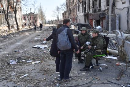 Мариуполь, Донецкая народная республика. Военнослужащие ДНР и местные  жители на улице разрушенного города.