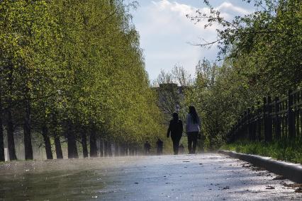 Екатеринбург. Парень и девушка идут по аллее во время дождя