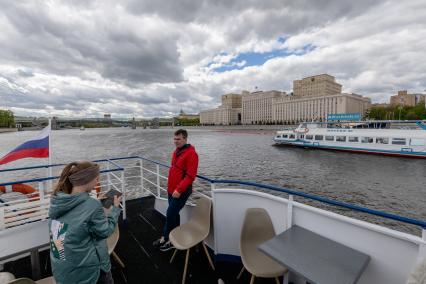 Москва. Мужчина фотографируется на фоне здания Министерства обороны во время экскурсии на теплоходе.