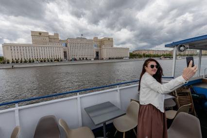 Москва. Девушка делает селфи на фоне здания Министерства обороны во время экскурсии на теплоходе.