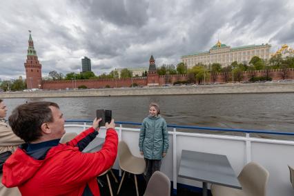 Москва. Девочка фотографируется на фоне Кремля во время экскурсии на теплоходе.