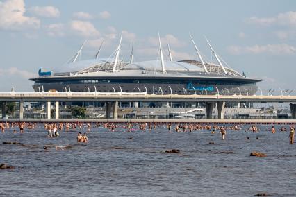 Санкт-Петербург. Люди купаются в Финском заливе с видом на стадион `Газпром-Арена`.
