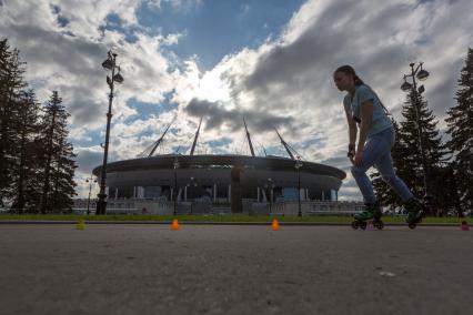 Санкт-Петербург. Девочка катается на роликах напротив стадиона `Газпром-Арена`.