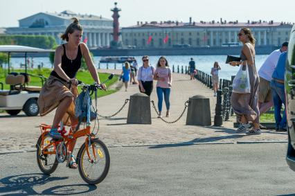 Санкт-Петербург. Девушка катается на велосипеде рядом с Биржевым мостом.