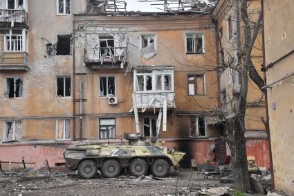 Донецкая область. г.Мариуполь. Бтр у жилого дома, пострадавшего в результате боевых действий.