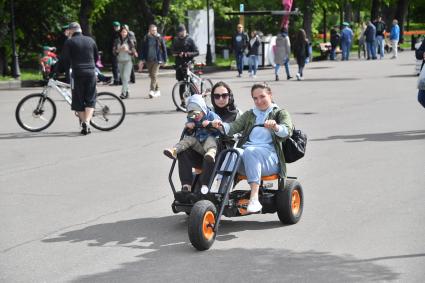 Москва. Горожане на веломобиле во время прогулки в Парке Горького.