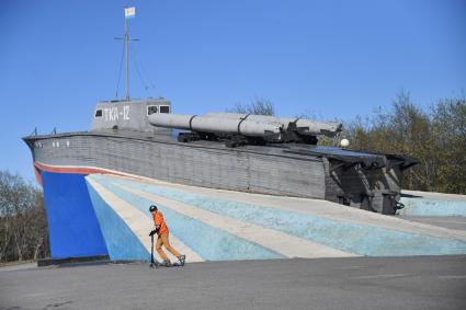 Североморск.  Мальчик на самокате у памятника `Торпедный катер `TK-12`.