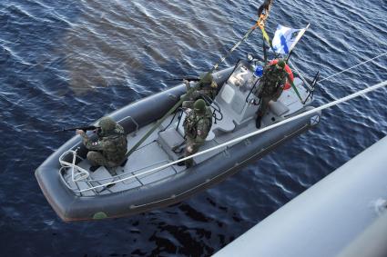 Североморск. Военнослужащие морской пехоты ВМФ РФ спускаются на воду в моторной лодке с борта тяжёлого атомного ракетного крейсера Петр Великий во время учений .