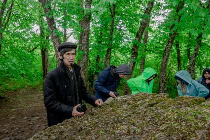 Республика Адыгея, п. Каменномостский. Хаджохский дольмен. Гид проводит экскурсию туристам.