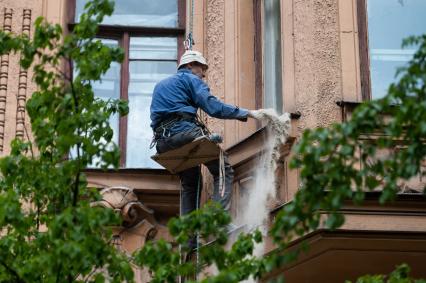 Санкт-Петербург. Промышленный альпинист во время ремонта фасада жилого дома.